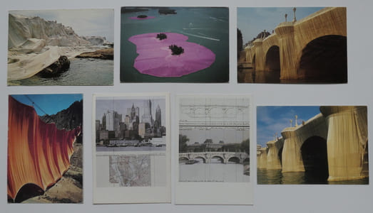 Réunion de 7 cartes cartes postales sur les réalisations et projets de Christo : La Côte Empaquetée. Le Rideau dans la Vallée. Le Pont-Neuf Empaqueté (2 vues). The Pont-Neuf Wrapped, project for Paris. Two Lower Manhattan Buildings, project for New York City. Les Iles Entourées.