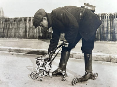 (Patins à roulettes motorisé) 2 tirages originaux argentiques représentant l'inventeur Mercier chaussé d'un patin automobile d'une force d'un cheval 1/4 pouvant faire 50km à la vitesse de 30km/h, moteur 2 cylindres, embrayage à friction, roues de boggies, pouvant monter les côtes de 8%. les accumulateurs et le bobine se tiennent dans une ceinture ainsi que le réservoir