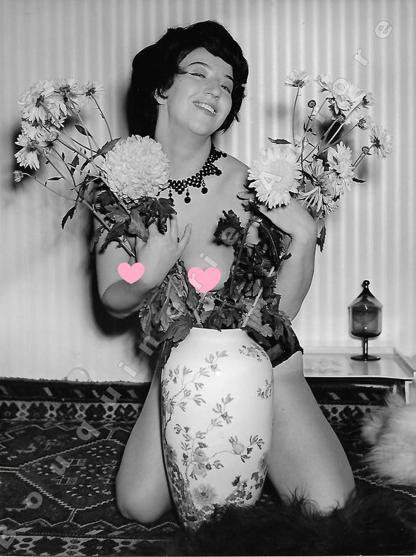 Jolie brune aux seins nus derrière un vase rempli de fleurs.Photographie originale en tirage argentique.. Fonds de la célèbre revue de Charme ...