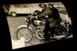 [Photographie originale figurant Georges Moustaki et sa fille  chevauchant une moto. . [MOUSTAKI (Goerges)] - VASSAL (Hugues, photogrpahie de).