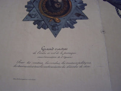 Grand crachat de l’ordre si vil de la perruque. (sous l’invocation de St Ignace) Pour les ventrus, les vendus, les sauteurs politiques, les charivarisés et tous les enthousiastes du désordre de chose. Légion d’horreur. (sous l’invocation de St. Loup)... Lithographie originale en couleur sur Velin blanc.