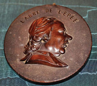 Médaillon en bois durci représentant l’abbé de l’épée (1712-1789), bienfaiteur de l’humanité.