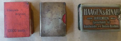 Ensemble de trois dictionnaire minuscules; 50x35mm.; à savoir: un Dictionnaire Poucet, Français-Anglais de chez Hatier; un Dictionnaire Français-Anglais de chez Schmidt & Günther et un Dictionnaire Français-Italien de chez Schmidt & Gunther. On joint un étui cuivré muet et un étui publicitaire de la Société Allemande Haagen & Rinau de Bremen spécialisé dans le matériel de boulangerie.