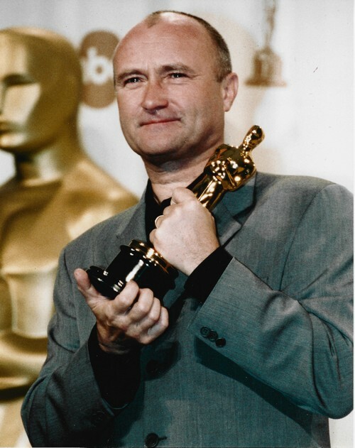Photographie en retirage couleurs, sur papier photo de Phil Collins recevant l'Oscar de la Meilleure chanson pour le film d'animation Tarzan.. ( ...