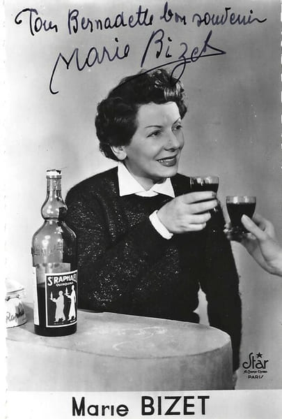 Photographie argentique du Studio Star, au format carte postale, repr&eacute;sentant Marie Bizet buvant un verre de Saint Rapha&euml;l, avec belle d&eacute;dicace de ...