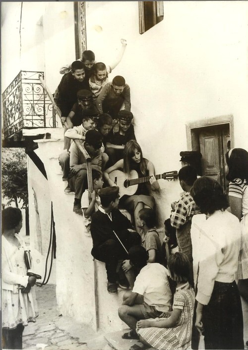 Photographie originale, en tirage argentique, de Fran&ccedil;oise Hardy jouant de la guitare pour de petis enfants grecs, entre deux prises du film " Une ...