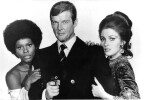 Photographie en tirage argentique en noir et blanc de Sir Roger Moore, entour&eacute; de Jane Seymour et Gloria Hendry, pour le film  "  Vivre et laisser ...