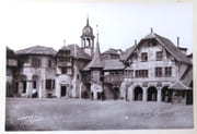 [Entrée du Village suisse - Maison du Chevalier (Schaffouse), Pont couvert de Lucerne, Maison au campanile d'Auvernier, Maison de Moudon].  par Boissonnas Fred.:  - Image 1