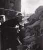 Gardien de la paix en tenue, grenade à la main, barricade de Belleville. . DOISNEAU (Robert).