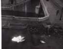 Véhicule détruit par des bouteilles incendiaires, quai de Seine. Photographie originale en tirage d'époque.. DOISNEAU (Robert).