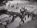 Groupe de FFI et de civils courant derrière une barricade dressée à l'angle de la rue Saint-Jacques et du boulevard Saint-Germain. Photographie ...